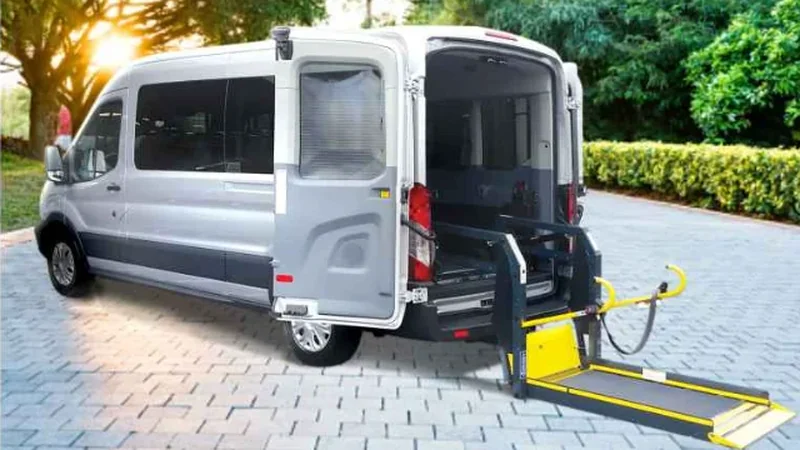 Wheelchair-accessible van with rear lift deployed and ramp extended for boarding